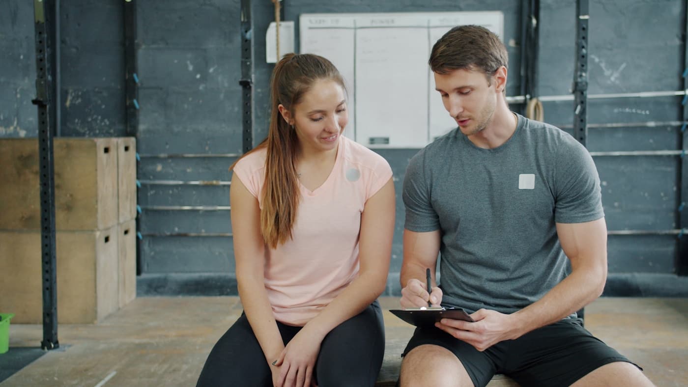 Coach and client reviewing a training plan together in a gym