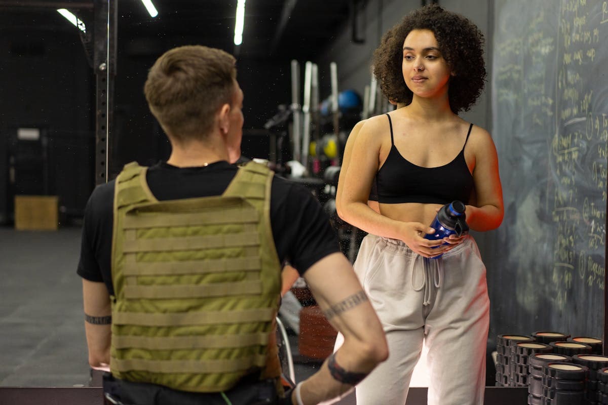 Coach and client talking between exercises in the gym