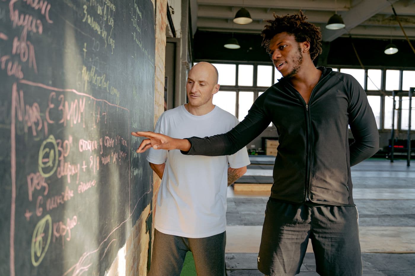 Coach explaining a training plan to a client in the gym
